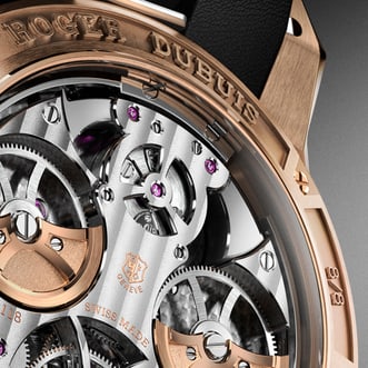 The image presents a close-up view of the back of the Grande complication. The composition is tightly framed, focusing on the movement and case back details.
