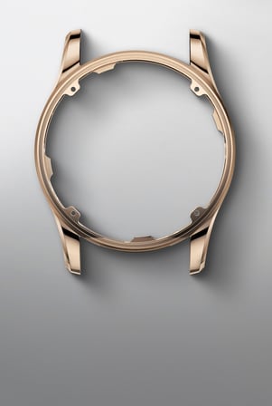 This image shows an empty, polished rose gold watch case, highlighting its elegant form and material.