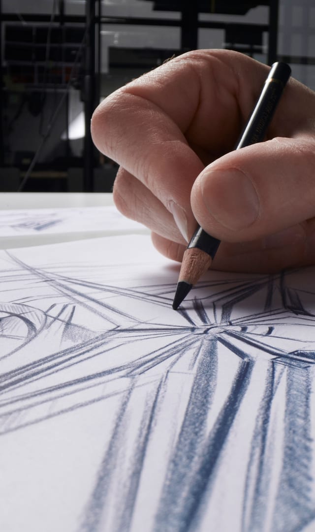 This image depicts a hand drawing the skeleton of a Roger Dubuis's watch.